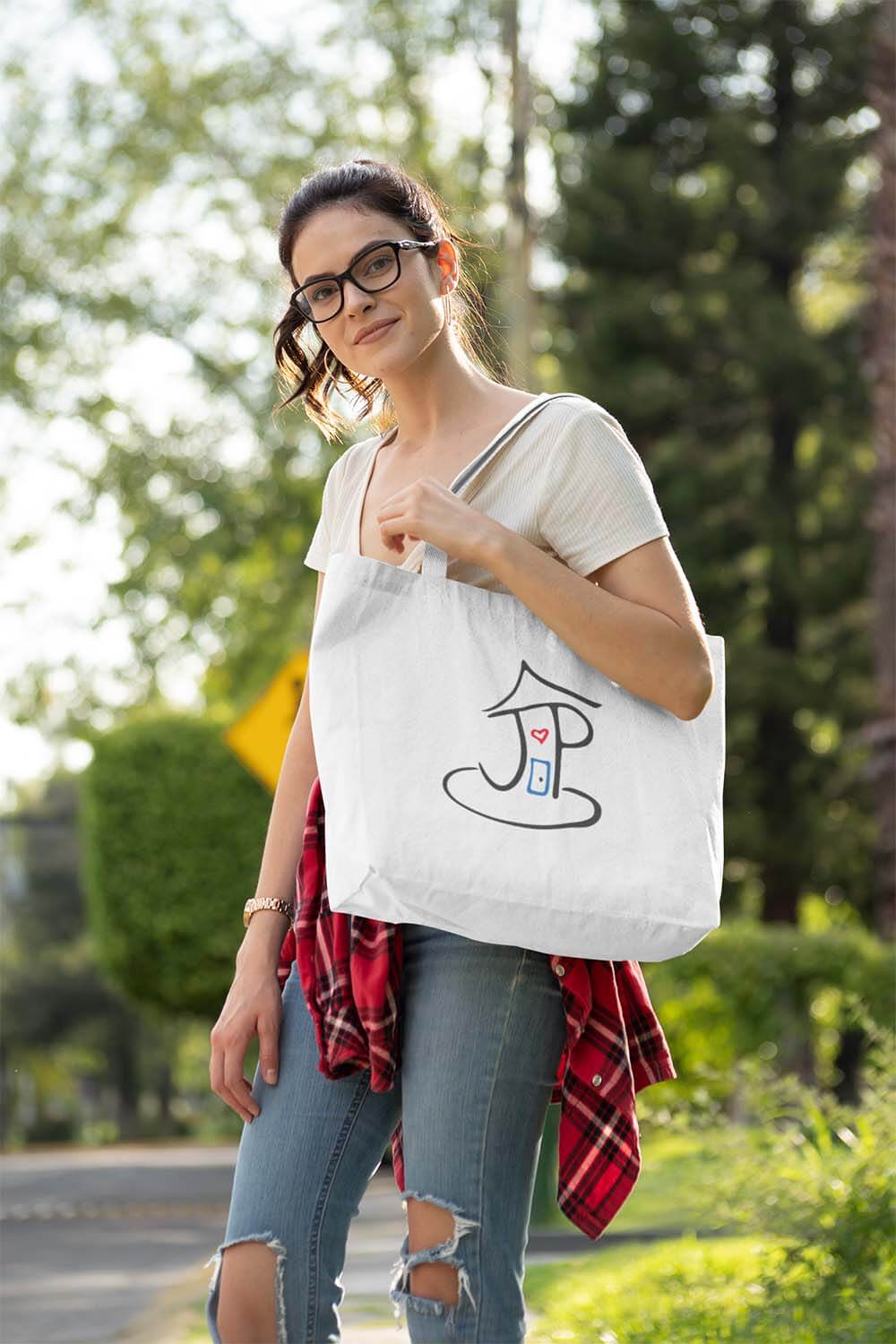 Woman carrying a large Jeremiah's Place JP tote bag outside