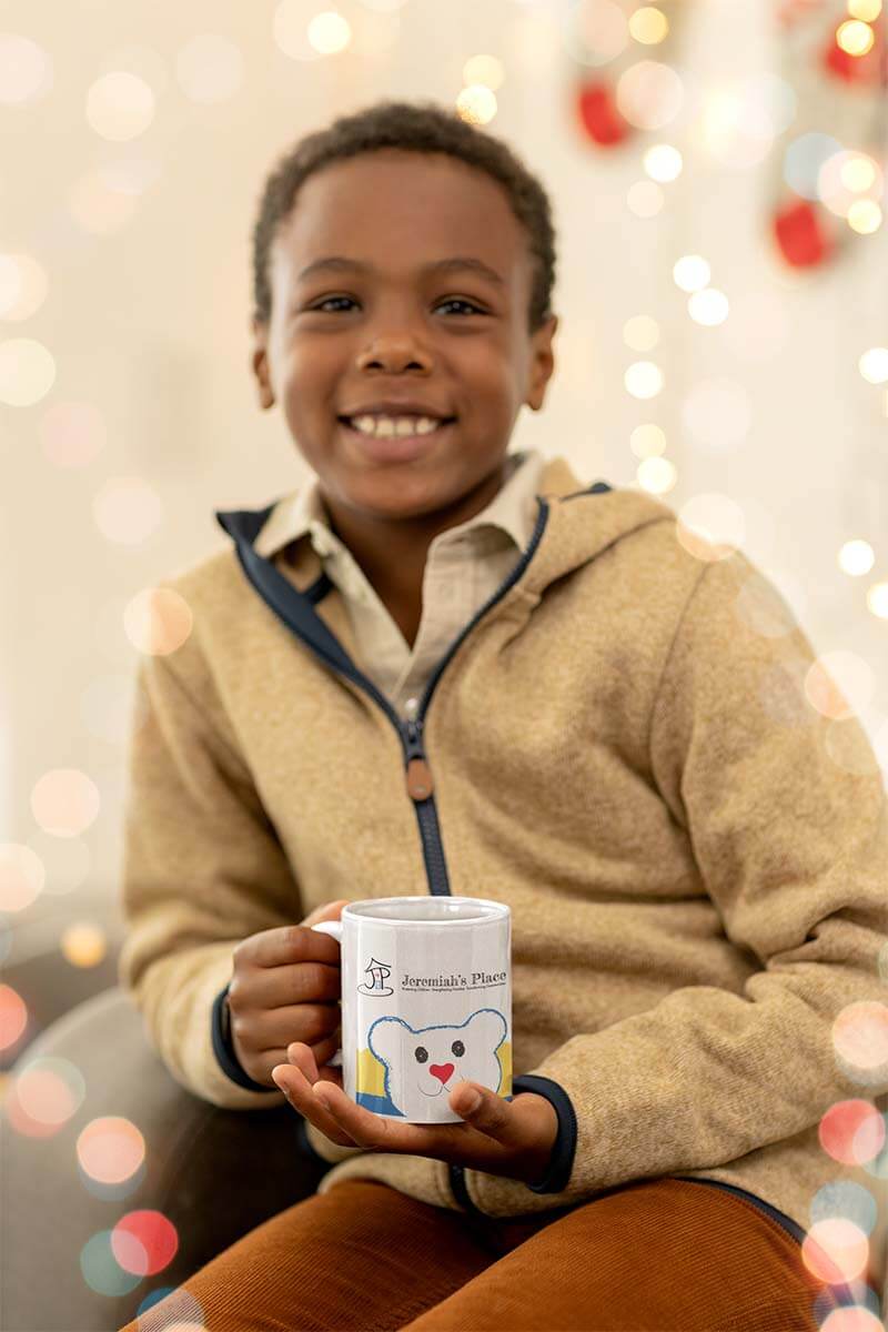 Young child holding a Jeremiah's Place JereBear ceramic mug